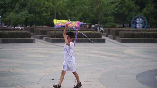城市公园人文小孩玩风筝拿着风筝走路运动视频素材模板下载