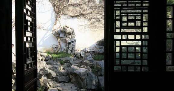 透过窗棂看苏州园林假山景致