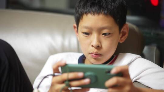 男孩在手机上玩游戏视频素材模板下载