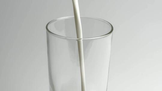 牛奶倒进透明玻璃杯里