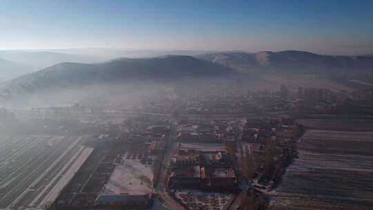 雾霭笼罩的乡村与田地的鸟瞰景象