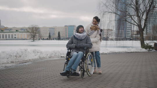妇女带着轮椅上的残疾朋友在城市里散步