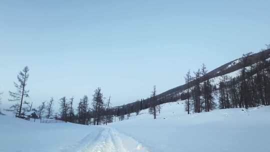 冬季喀纳斯湖雪山脚下汽车在积雪路面上行驶