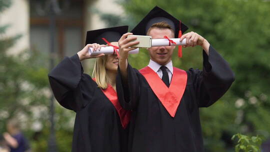 毕业典礼后身着学院服装的研究生自拍视频素材模板下载