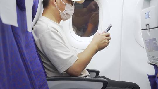 疫情期间男子在飞机上用手机刷视频