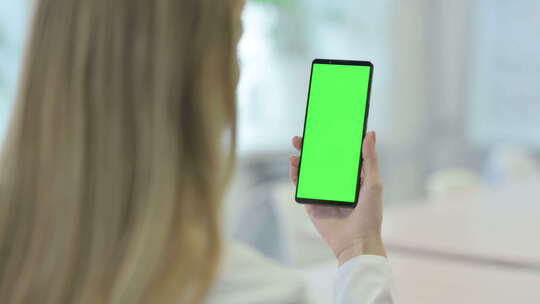 使用带有绿屏色度键的智能手机的女性视频素材模板下载