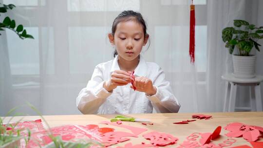 认真玩剪纸游戏的中国女孩