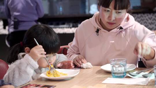 在餐厅开心用餐的母亲和女儿