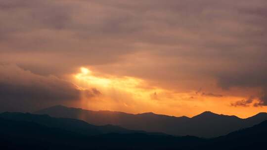 山间日落霞光穿透云层