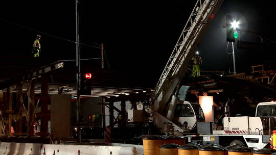 夜间建筑工人在高速公路立交桥上工作的延时镜头