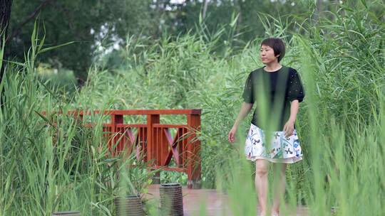 4K升格夏季在公园荷花池芦苇游玩的东方女性