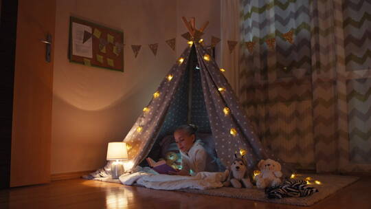 女孩在帐篷里读完书关灯睡觉
