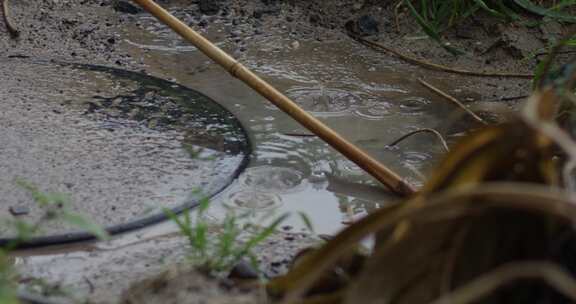 雨水落在水泥附近的泥泞水坑上