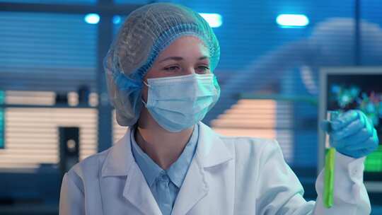 一位女科学家手持绿色试管，提取新鲜细胞
