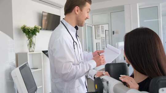 脊椎诊所的医生检查一名年轻妇女的脊柱诊断视频素材模板下载