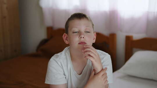 疲惫的过敏反应和肿胀的脸的孩子坐在房间里