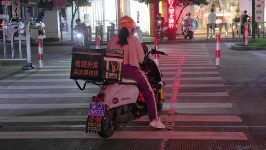 夜景街道：美团女骑手等候红绿灯