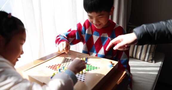 中国小孩在窗边下棋跳跳棋