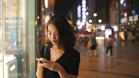 一位中国美女在成都街头看手机发消息