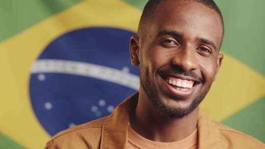 微笑的黑人在巴西国旗上摆姿势视频素材模板下载