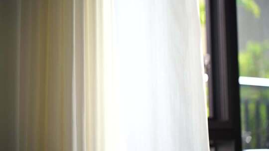 风吹窗帘窗户白色窗帘飘动阳光透过白色窗帘