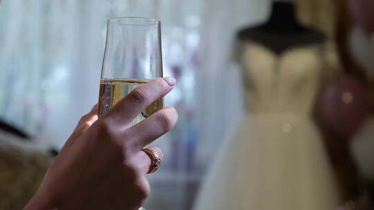 54秒。女人在婚纱的背景上拿着一杯香槟。