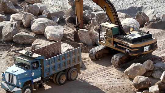 挖掘起重机将岩石吊上卡车