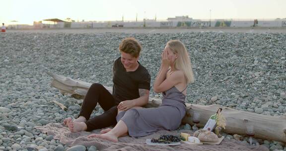情侣坐在岩石沙滩聊天