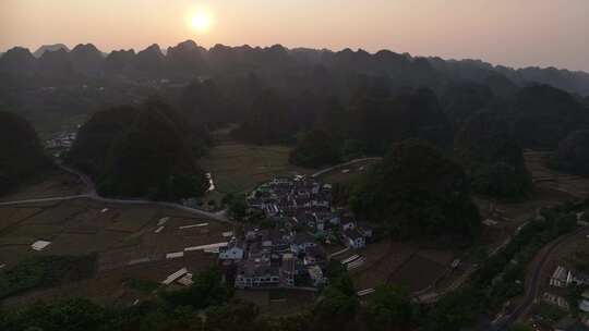 日出时分的山间村庄与农田鸟瞰全景