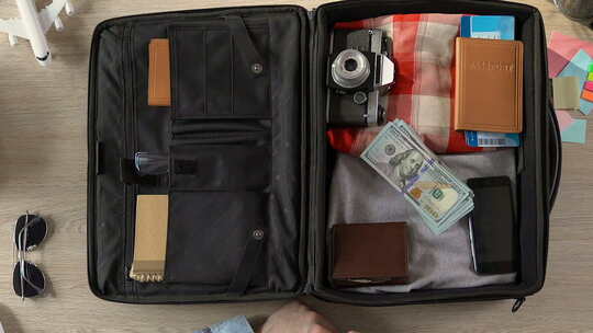 旅行者打包他的手提箱，把钱包、护照和票和钱放在一起