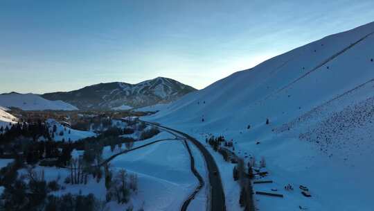 爱达荷州太阳谷滑雪场附近穿过雪山的一条路的风景。空中广角拍摄