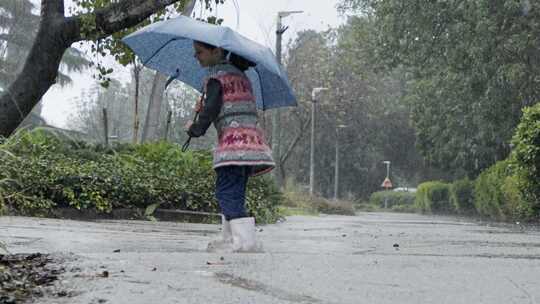 女孩在雨中的水坑里玩耍