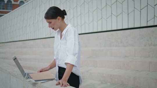 女孩自由职业者在户外工作笔记本电脑在街上检查文件中的信息视频素材模板下载