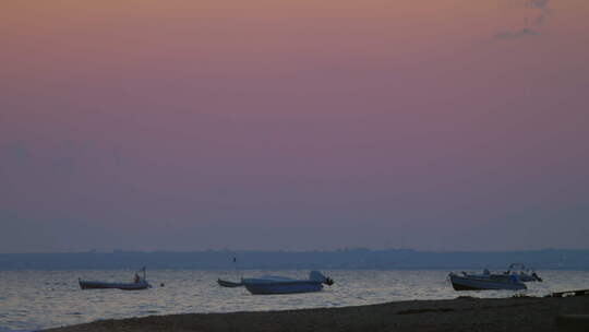 停泊的摩托艇在黄昏的海浪中摇摆