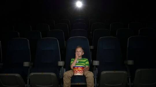 小男孩独自在电影院看电影视频素材模板下载