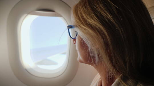女商人在飞机上向窗外望去