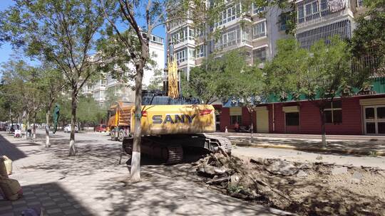 挖掘机揭去城区柏油路面装入渣土车视频素材模板下载