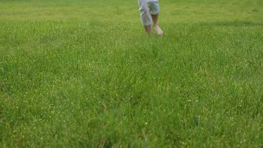 赤脚奔跑在绿色的草地上视频素材模板下载