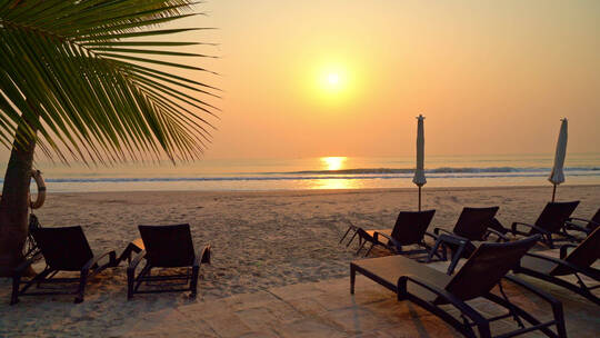 夕阳海边沙滩躺椅椰子树