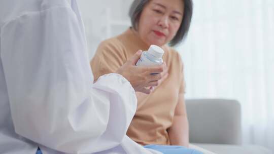 亚洲高级女病人在疗养院向内科护士咨询。