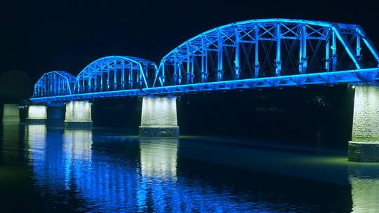 鸭绿江上断桥夜景蓝色灯光倒映江面上
