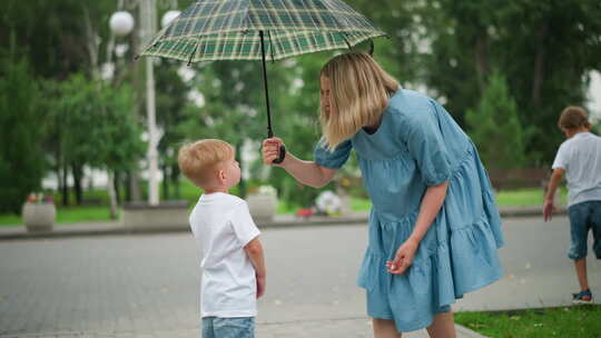 当儿子伸手去拿雨伞时，母亲开玩笑地和他说