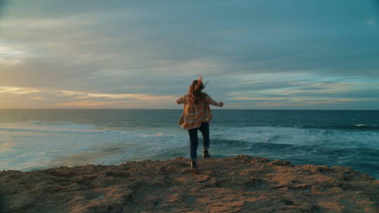 女人在日落时奔向海洋