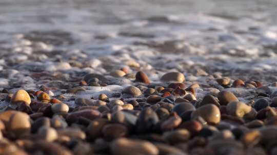 4K-海边海水泡沫冲击鹅卵石的特写视频素材模板下载