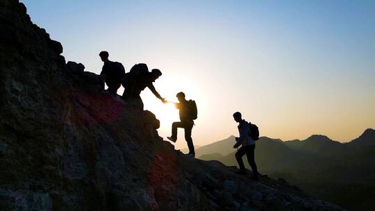 团队登山剪影手拉手爬山团队精神攀登顶峰