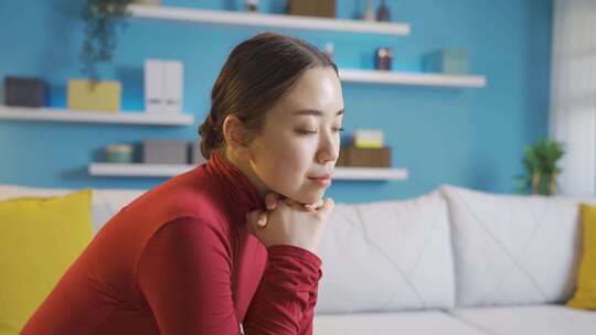 室内沙发上沉思的红衣女子