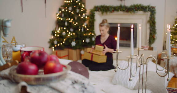 女子坐在地毯上包装圣诞礼物