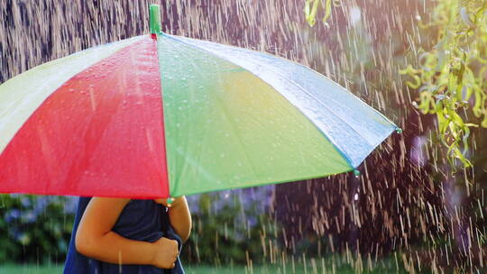 小女孩在彩色雨伞下躲雨