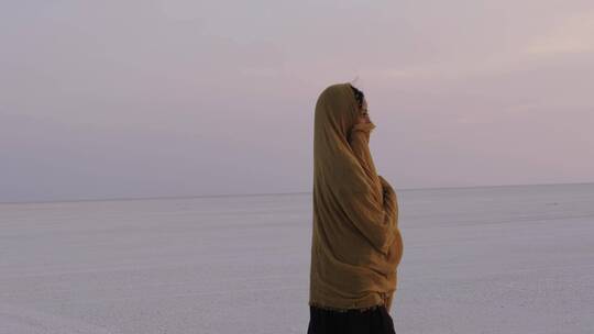 沙漠中围纱巾行走的女人