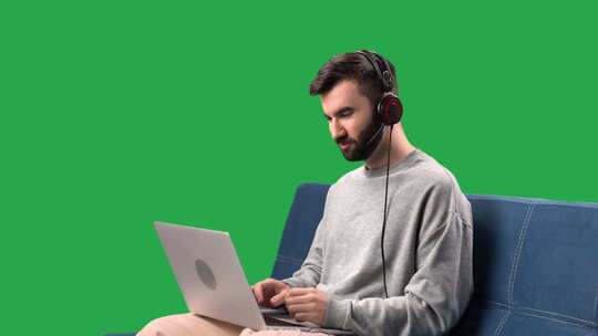 男人说话在线视频通话使用笔记本电脑在沙发上远程会面隔离绿屏色度键